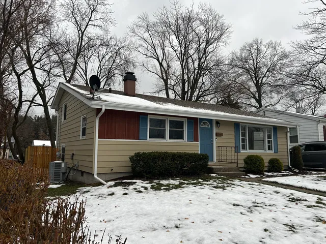 a front view of a house with a yard covered in snow