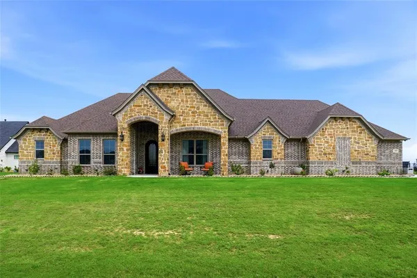 a view of a house with a big yard and large trees