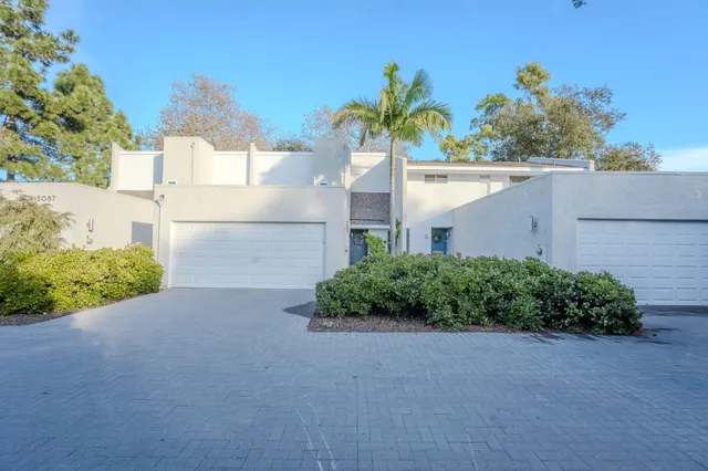 a front view of a house with a yard and plant