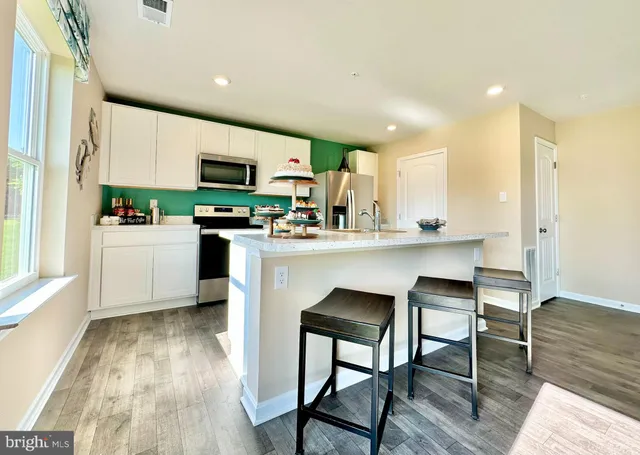 a kitchen with a table chairs refrigerator and cabinets
