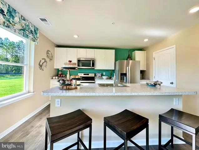 a kitchen with stainless steel appliances a microwave a stove and white cabinets