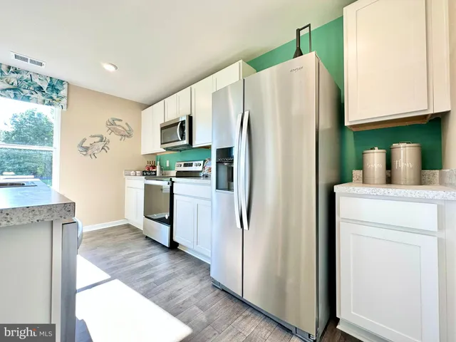 a kitchen with stainless steel appliances a refrigerator sink and microwave