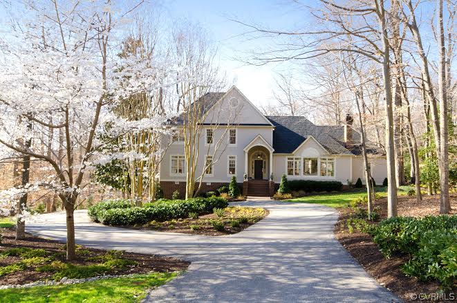a front view of a house with yard and green space