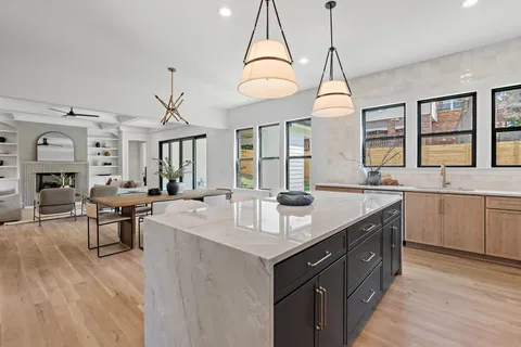 a large kitchen with kitchen island a stove a sink a island and windows