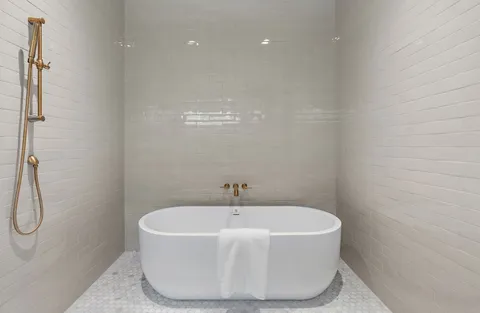 a bathroom with a white bath tub and a shower