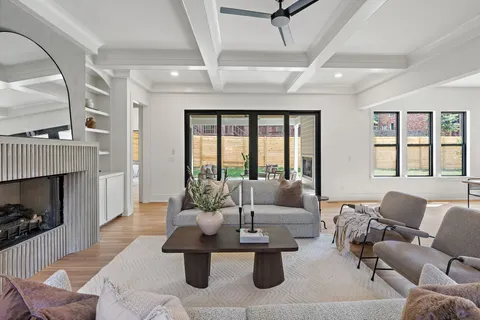 a living room with furniture a fireplace and a chandelier