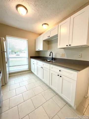 a kitchen with a sink a stove and cabinets