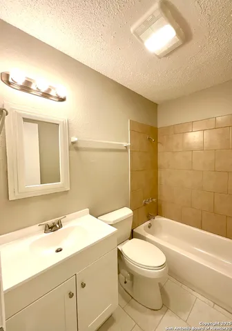 a bathroom with a toilet a sink a mirror and bathtub