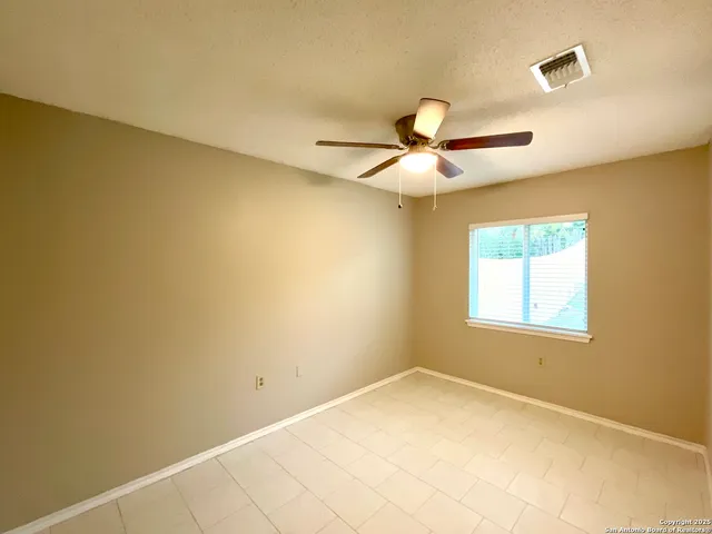 a view of a room with a ceiling fan and a window