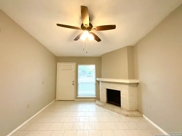 a view of a livingroom with a ceiling fan and fireplace