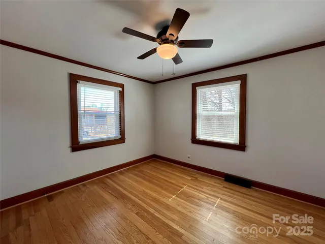 a view of empty room with wooden floor