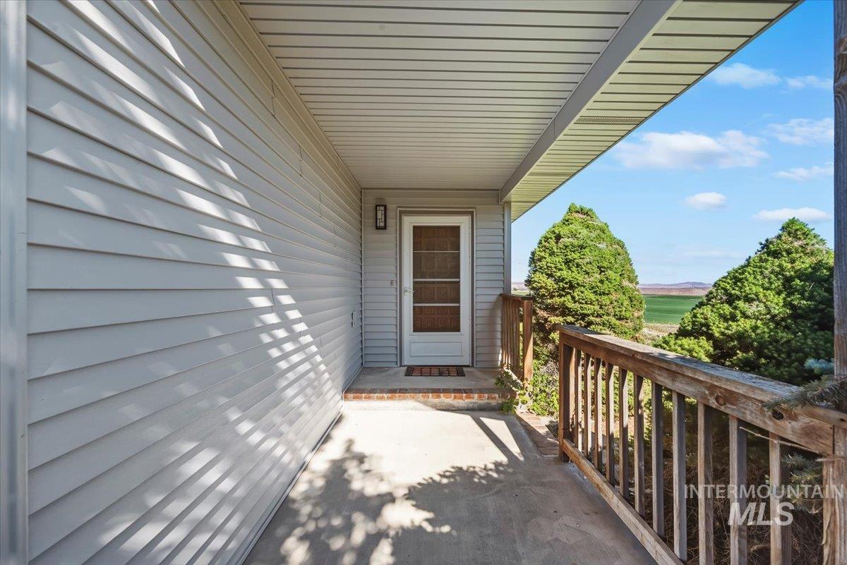 2331 Gulley Road Homedale, ID 83628 - Photo 4 of 46 Covered porch entry featuring a white screen door, exterior light fixture, and wood railing