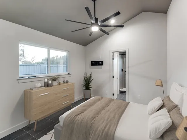 a bedroom with a bed and a large window