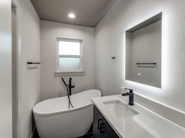 a bathroom with a granite countertop sink a toilet and mirror