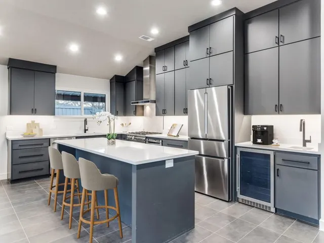 a kitchen with stainless steel appliances granite countertop a sink refrigerator and microwave