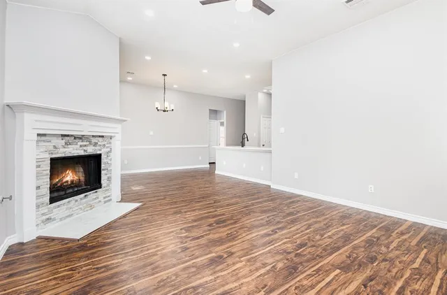 a view of empty room with wooden floor and fireplace