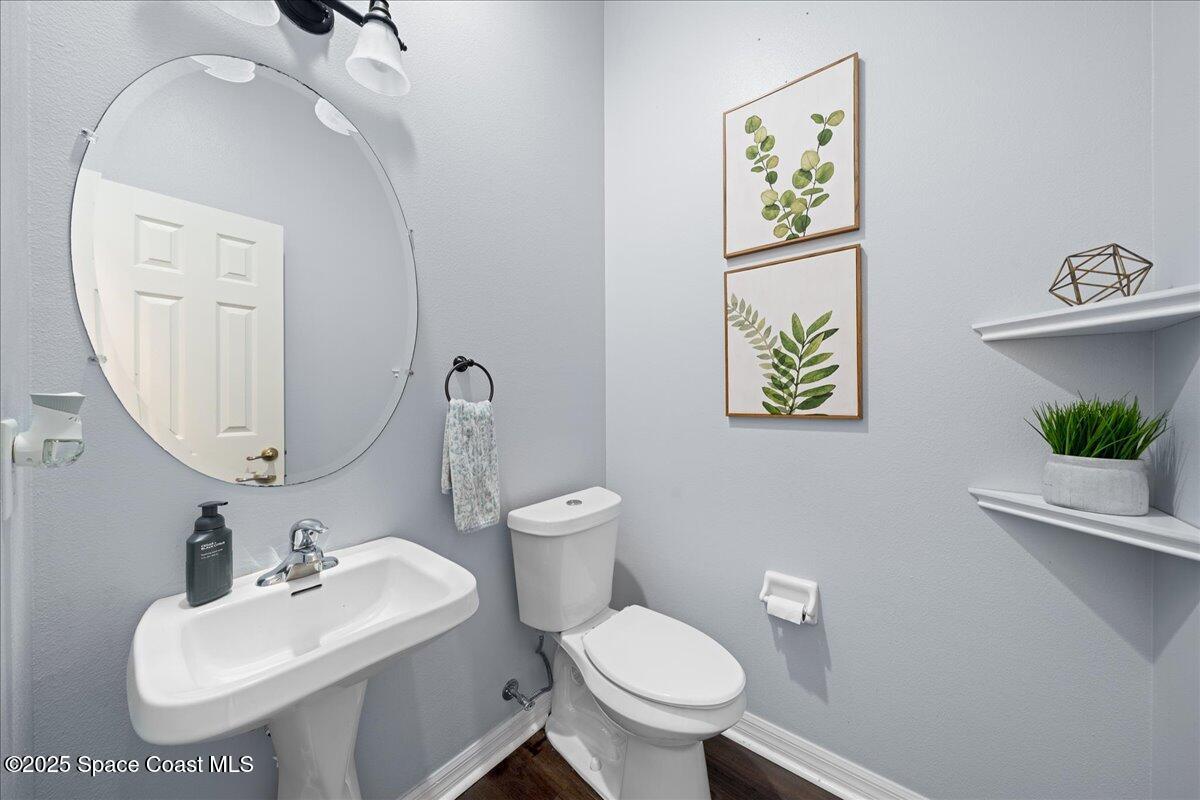 2409 Granger Road Cocoa, FL 32926 - Photo 31 of 36 a bathroom with a toilet sink and mirror