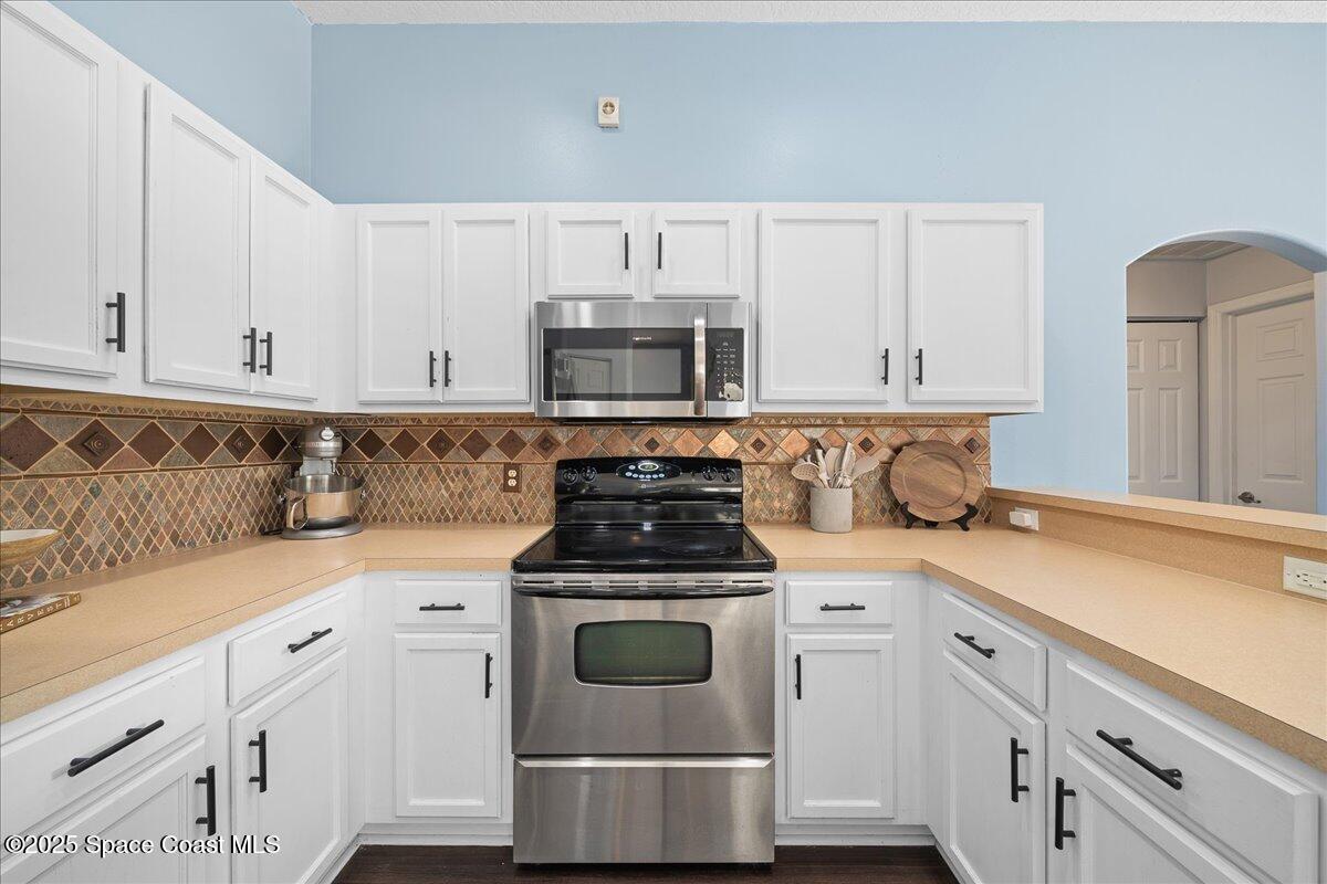 2409 Granger Road Cocoa, FL 32926 - Photo 7 of 36 a kitchen with granite countertop white cabinets and white appliances