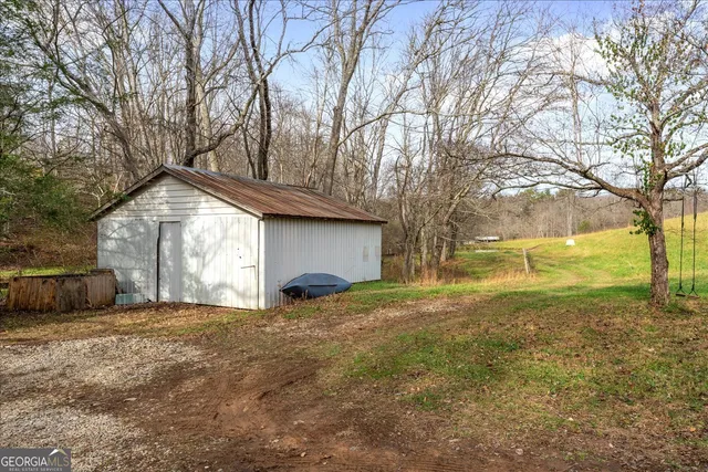 a view of a house with backyard and trees