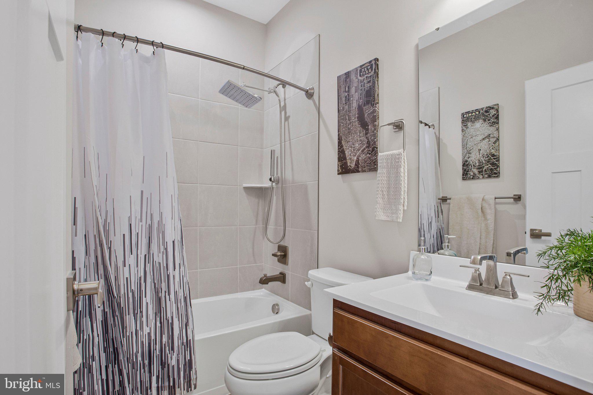9012 Waller Tree Way Upper Marlboro, MD 20772 - Photo 18 of 29 a bathroom with a sink a toilet a mirror a bathtub and shower