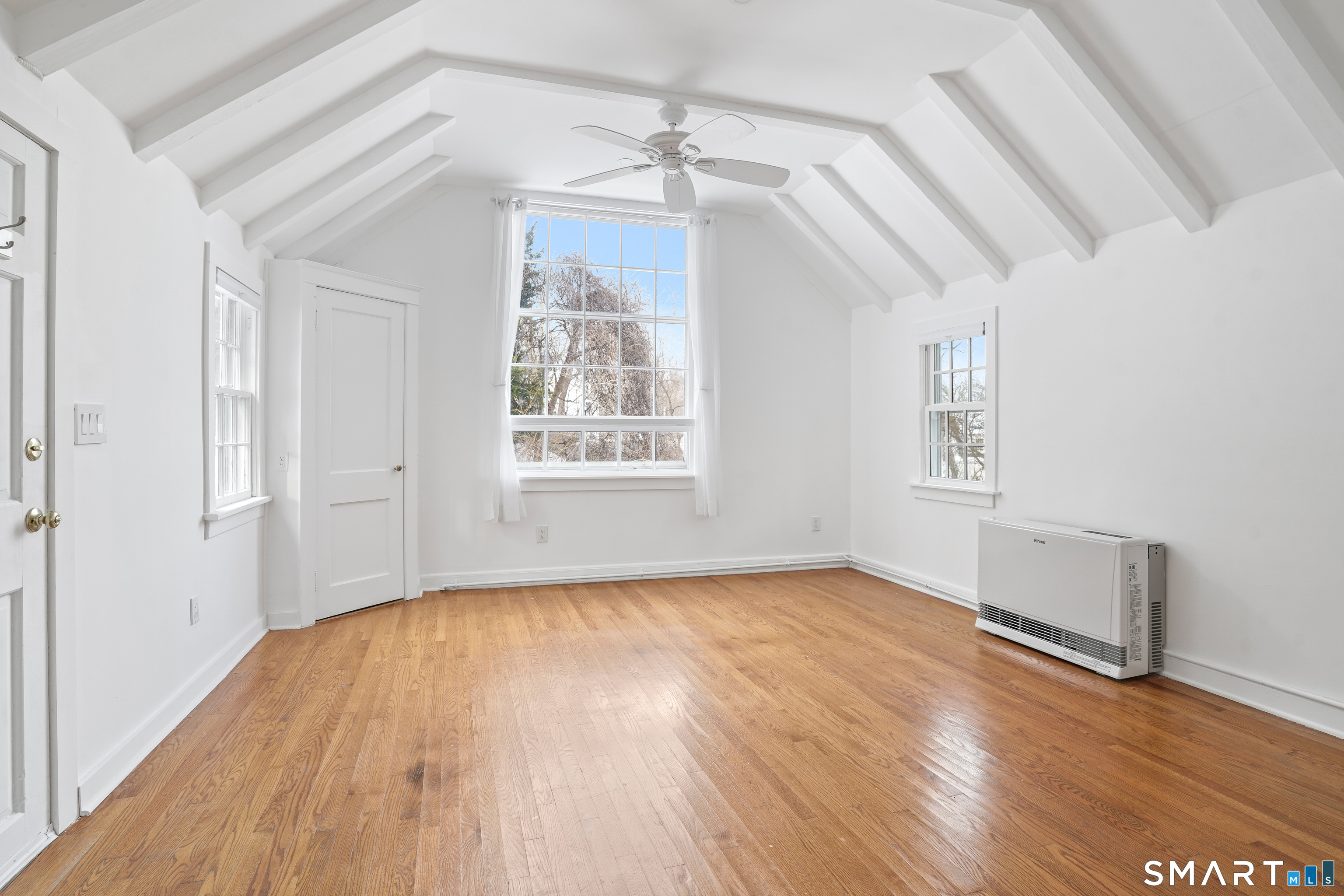 69 Sylvan Road North, Unit COTTAGE Westport, CT 06880 - Photo 3 of 11 an empty room with wooden floor chandelier and windows