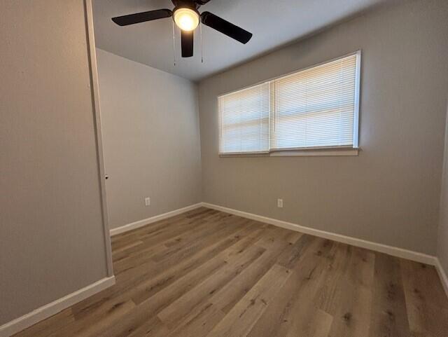 4410 43rd Street Lubbock, TX 79414 - Photo 5 of 9 an empty room with wooden floor chandelier fan and windows