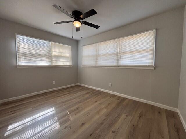 4410 43rd Street Lubbock, TX 79414 - Photo 7 of 9 an empty room with wooden floor and windows