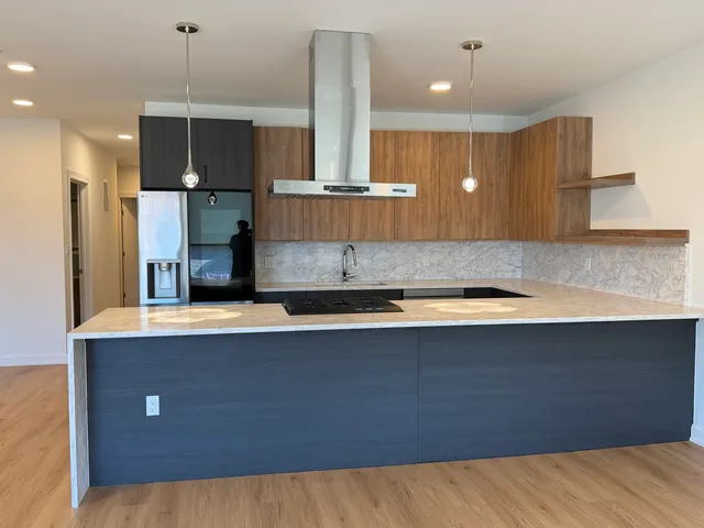 a kitchen with kitchen island a sink stainless steel appliances and cabinets