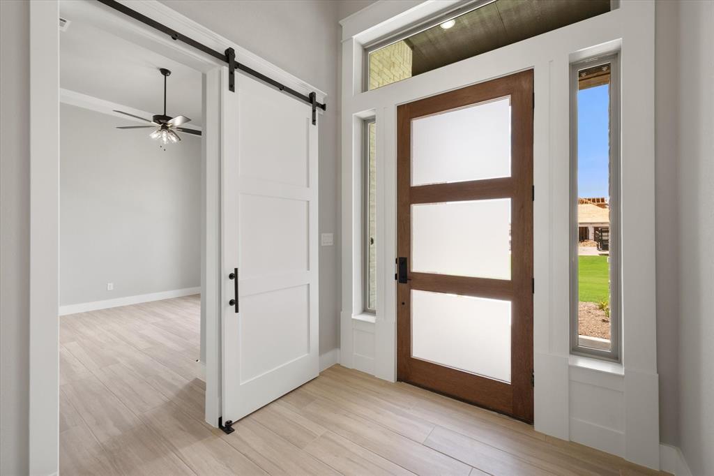6610 Waggoner Way Midlothian, TX 76065 - Photo 6 of 40 Modern wood-finish front door with frosted glass panels, flanked by sidelight windows and a transom window