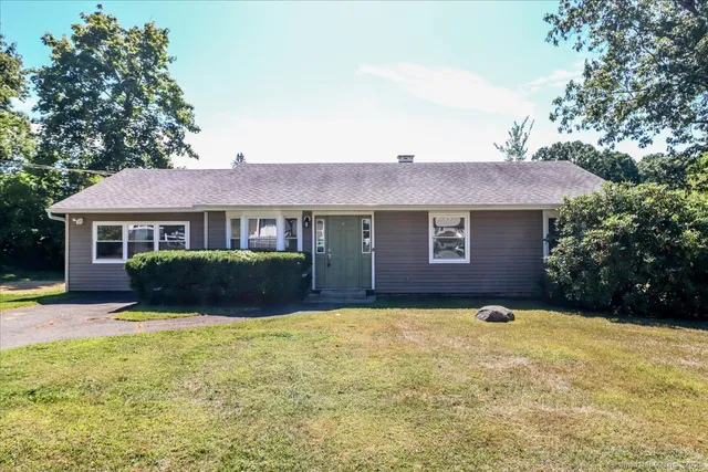 a view of a house with a yard and sitting area