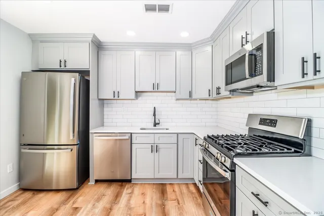 a kitchen with a sink a microwave a refrigerator and cabinets