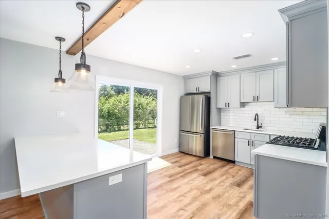 a kitchen with a refrigerator a stove a sink and a window