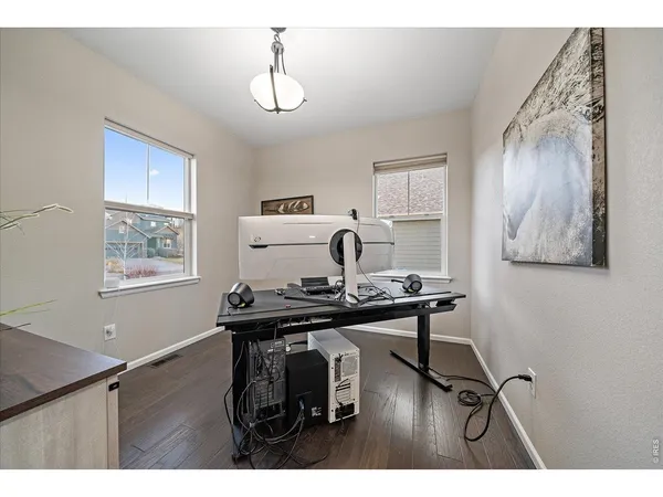 a dining room with lots of wooden furniture a chandelier and wooden floor