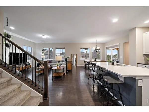 a outdoor dining room with furniture large windows and a chandelier