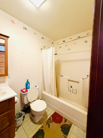 a bathroom with a granite countertop sink mirror vanity and toilet