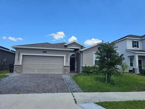 a front view of a house with a yard and garage