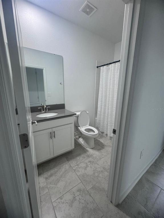 3071 Camden Way Davenport, FL 33837 - Photo 18 of 44 a kitchen with a stove and white cabinets