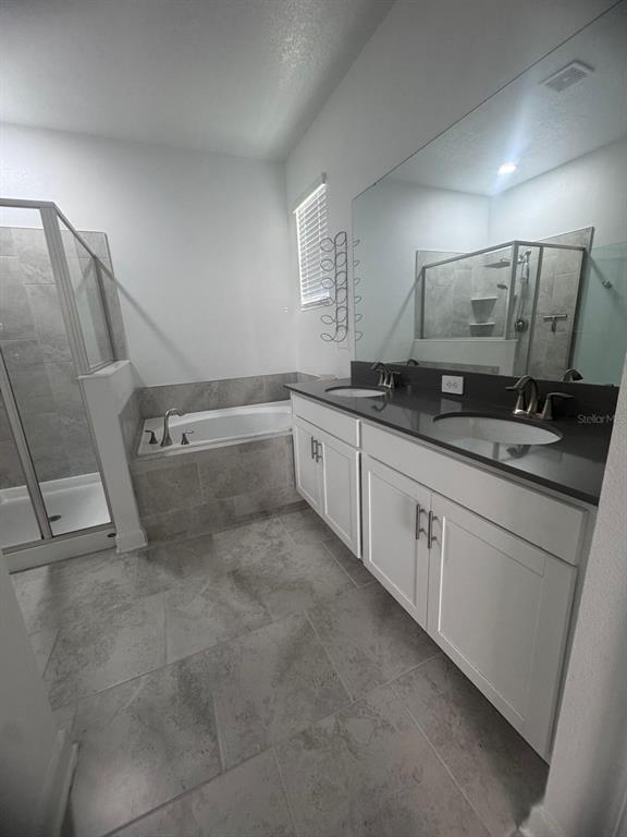 3071 Camden Way Davenport, FL 33837 - Photo 22 of 44 a spacious bathroom with a granite countertop sink a toilet a mirror and vanity