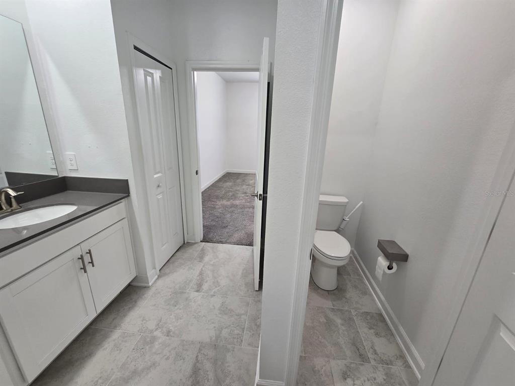 3071 Camden Way Davenport, FL 33837 - Photo 36 of 44 a bathroom with a granite countertop sink toilet and shower