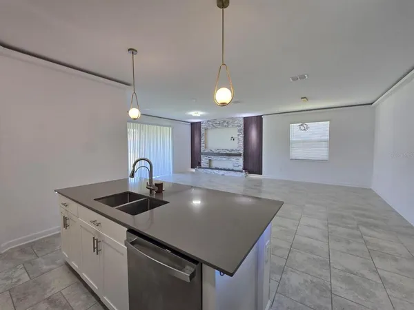 a view of a kitchen with wooden floor electronic appliances and furniture