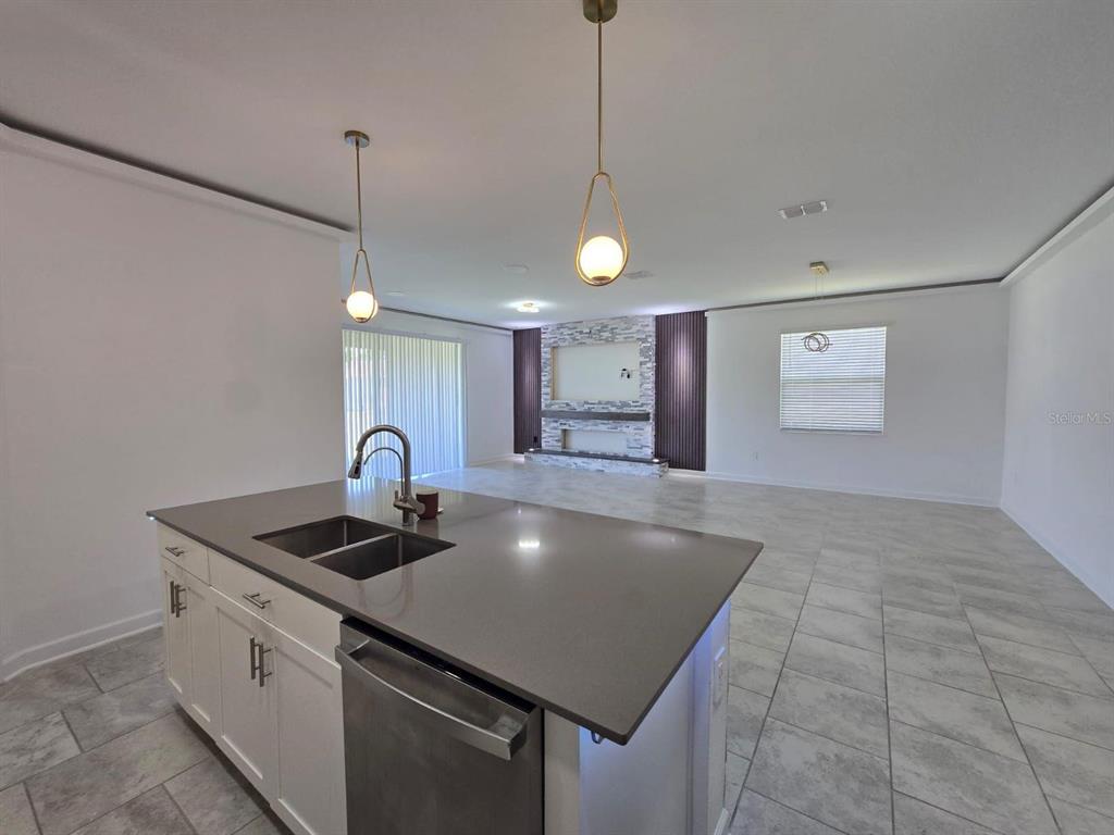 3071 Camden Way Davenport, FL 33837 - Photo 7 of 44 a kitchen with kitchen island a sink stainless steel appliances and a chandelier