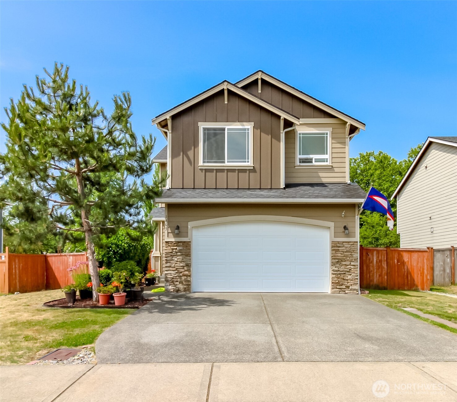 1605 Riddell Avenue Northeast Orting, WA 98360 - Photo 1 of 35 a front view of a house with a yard and garage