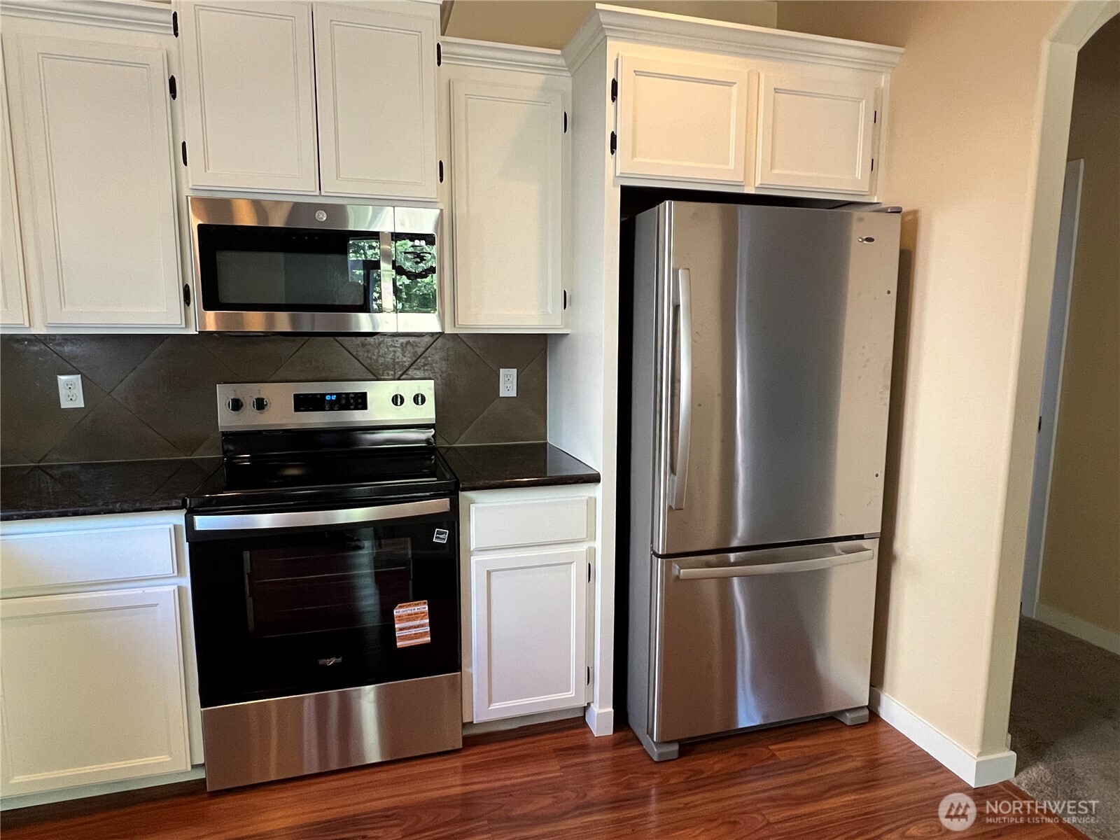 1605 Riddell Avenue Northeast Orting, WA 98360 - Photo 11 of 35 a kitchen with stainless steel appliances a refrigerator stove and microwave