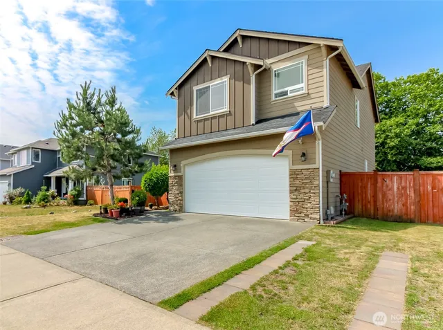 a view of a house with many windows and a small yard