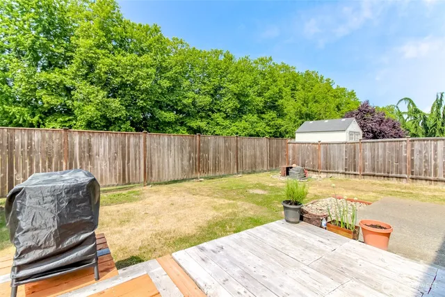 a backyard with table and chairs and wooden fence