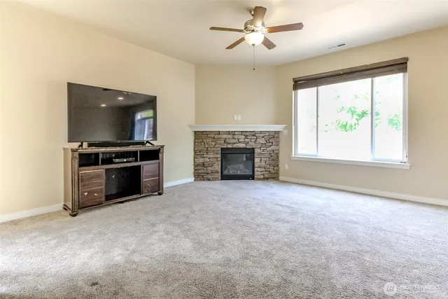 a view of an empty room with a fireplace and a window