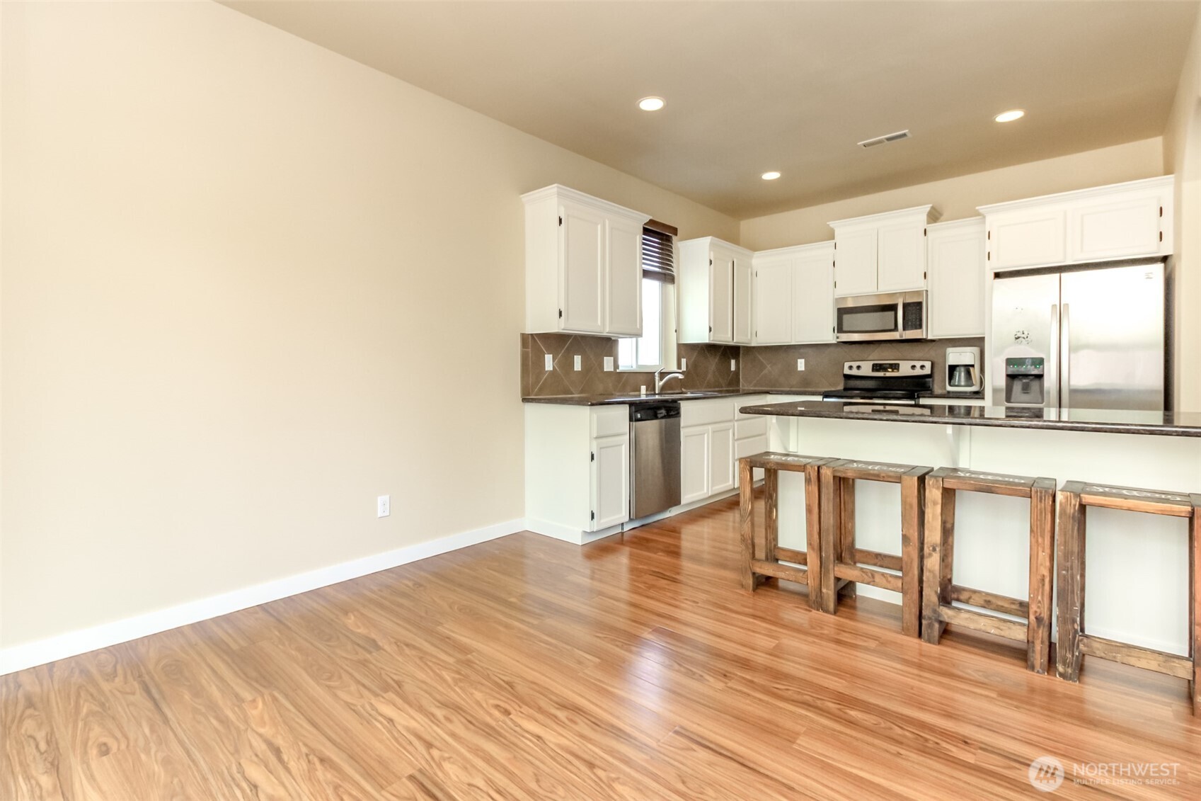 1605 Riddell Avenue Northeast Orting, WA 98360 - Photo 9 of 35 a kitchen with stainless steel appliances granite countertop a stove top oven a sink and white cabinets