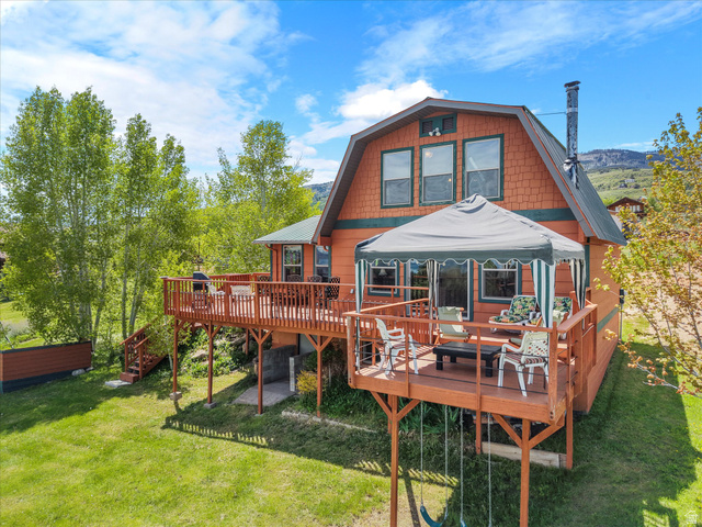 371 Lewis Loop, Unit 29 Fish Haven, ID 83287 - Photo 6 of 40 Two-story gambrel-roof residence featuring an expansive wooden deck with a covered outdoor area