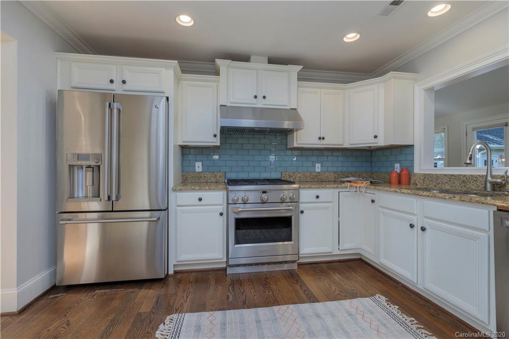 635 Marsh Road Charlotte, NC 28209 - Photo 19 of 48 a kitchen with cabinets stainless steel appliances and wooden floor