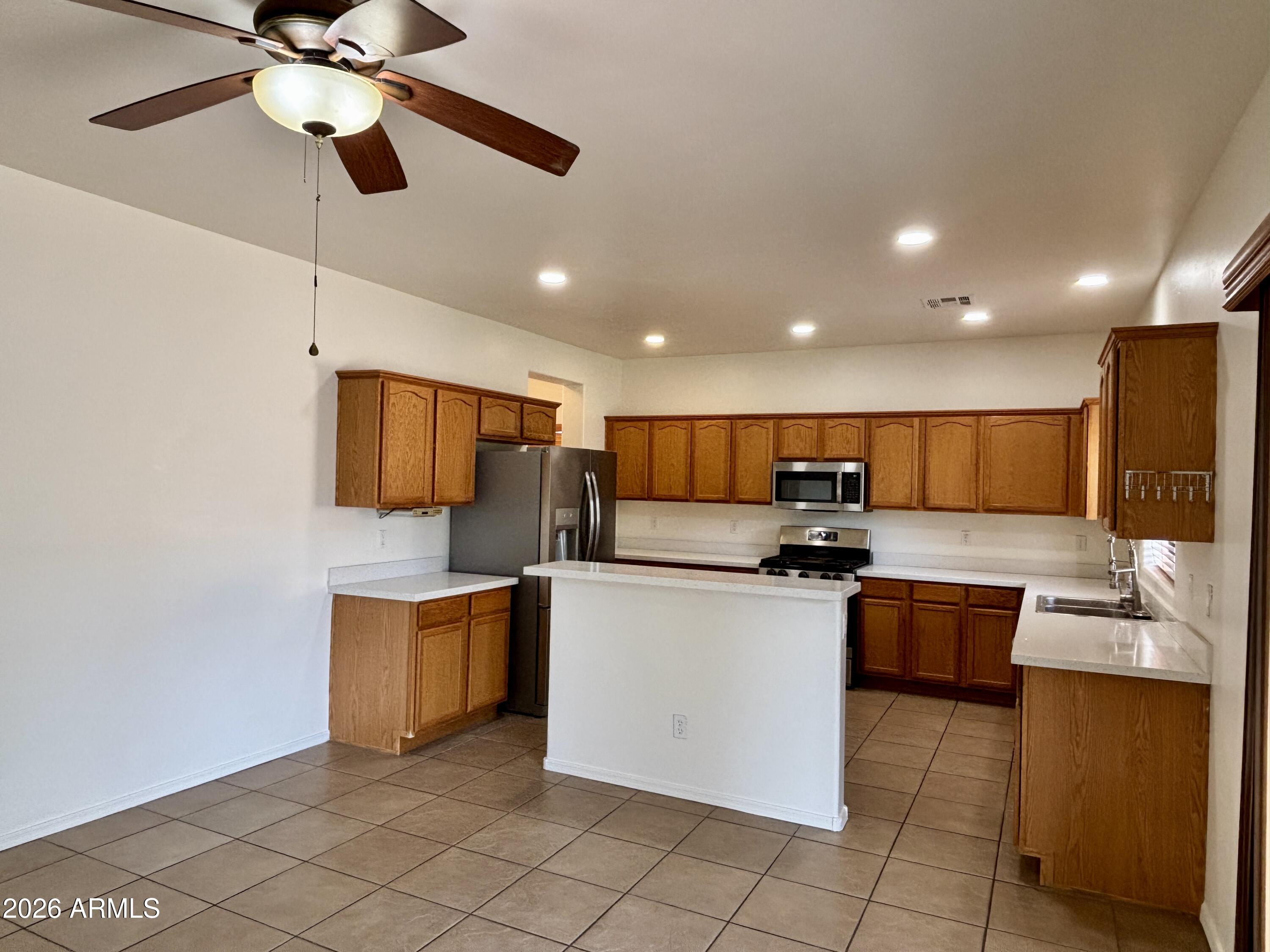 160 North Pottebaum Road Casa Grande, AZ 85122 - Photo 9 of 47 a kitchen with stainless steel appliances a stove top oven a sink a dining table and chairs